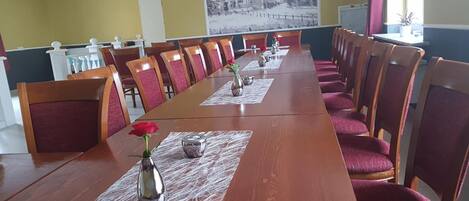 A conference room with a long table, red chairs, and a whiteboard.
