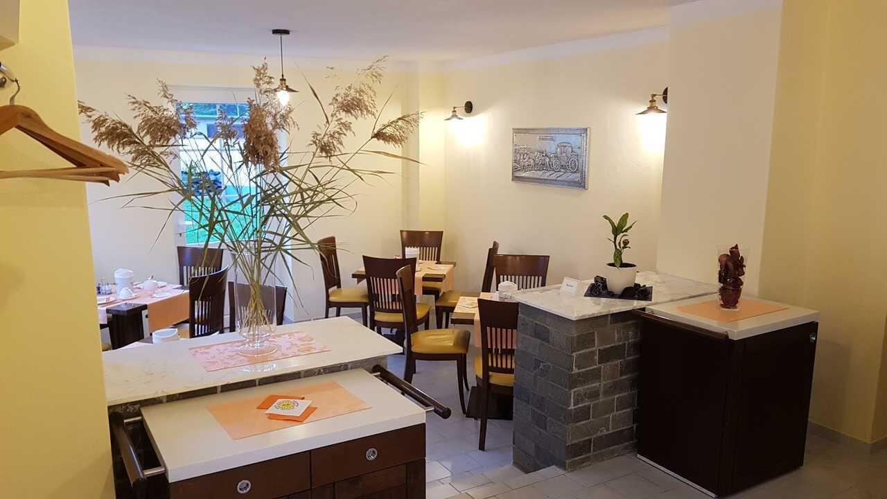 A dining area with a table, chairs, and a potted plant.