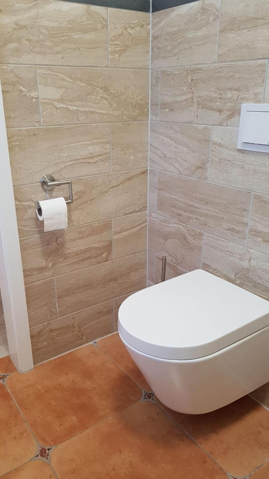 Ein Badezimmer mit Toilette und Duschbereich.