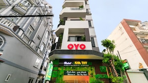 A hotel named 'OYO' with a modern design, balconies, and a signboard with contact information. - Kha Thy Hotel (Ho Chi Minh City)