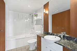 Un baño moderno con bañera, inodoro y lavamanos.