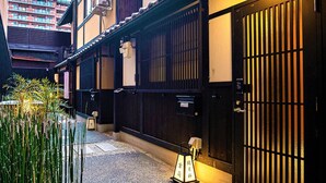 A traditional Japanese building with a black gate and a small lantern. - Kyorana Kyogetsutei (Kyoto)