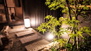 A traditional Japanese garden with stone lanterns and a pathway. - Kyorana Kyogetsutei (Kyoto)