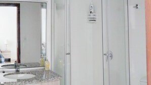 Une salle de bain moderne avec une douche à parois de verre, un meuble-lavabo à deux vasques et des toilettes.