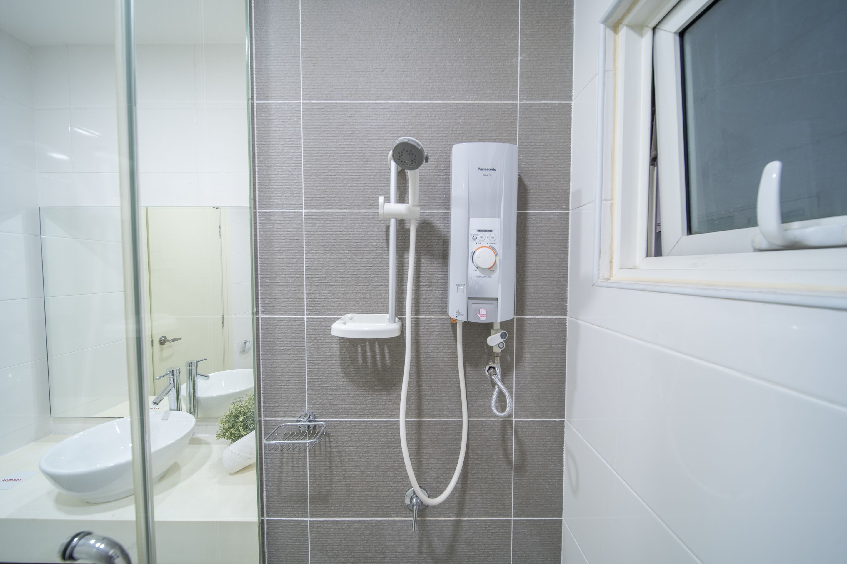 A modern bathroom with a glass shower enclosure, a built-in sink, and a toilet.