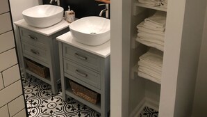 A bathroom with two white sinks, a mirror, and a towel rack.