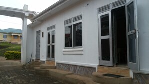 Une maison à deux étages avec un porche à l’avant, une porte de garage et un escalier menant à l’entrée.
