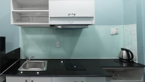 Een moderne keuken met een zwart aanrecht, een roestvrijstalen spoelbak en een ingebouwde oven.