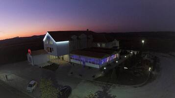 Vista frontal de la propiedad por la tarde o noche