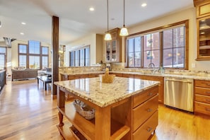 Kitchen with island, granite countertop, stainless steel appliances, and wooden cabinetry.