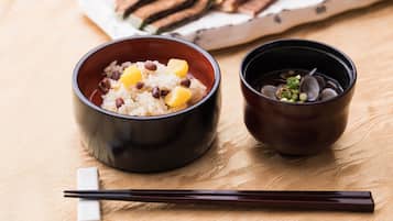 Two bowls of food on a table with chopsticks and a napkin.