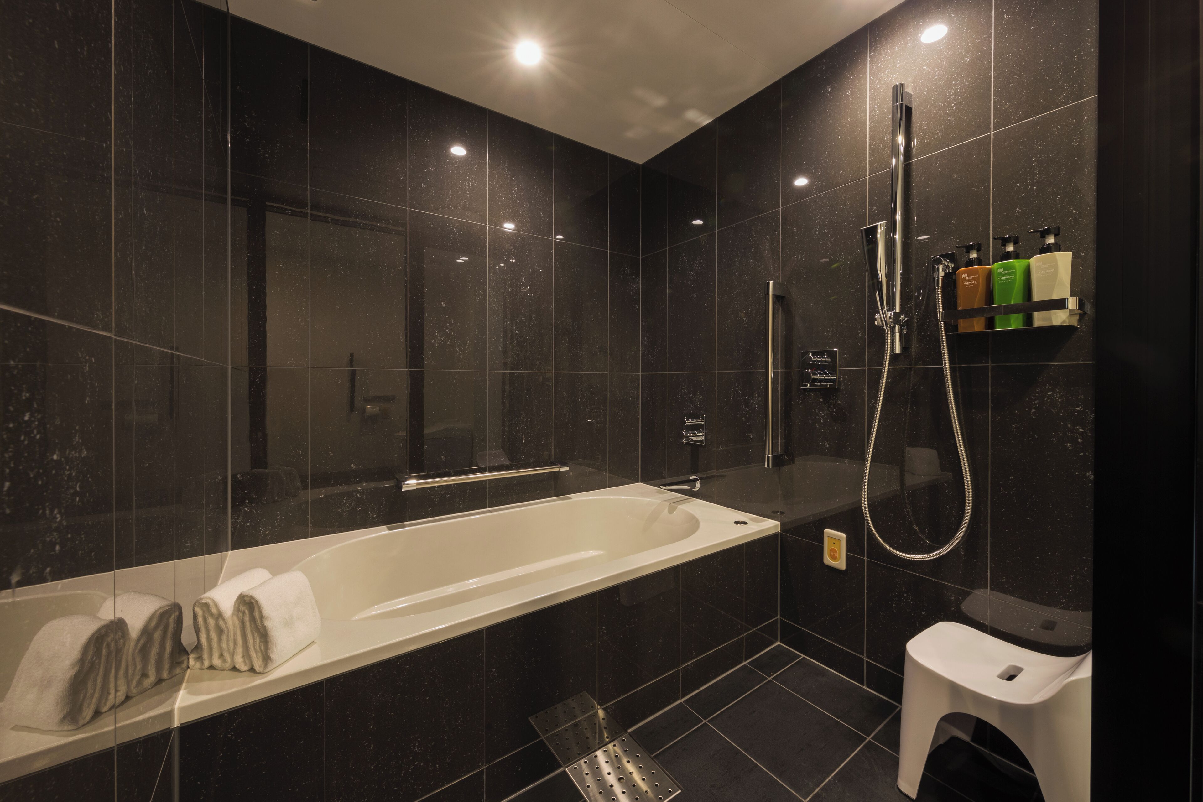 A modern bathroom with a large bathtub, a shower area, and a toilet.