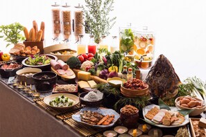 Un buffet proposant une variété de plats, notamment des viandes, des légumes et des fruits.
