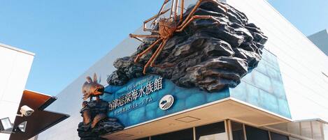 A building with a large sign featuring a giant crab and a sea turtle, indicating a marine-themed attraction.
