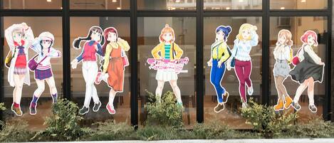A building facade with large windows displaying cut-out figures of animated characters.