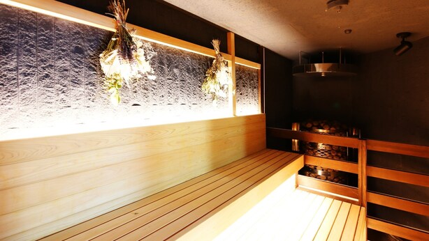 Sauna amb seients de fusta i paret de vidre.