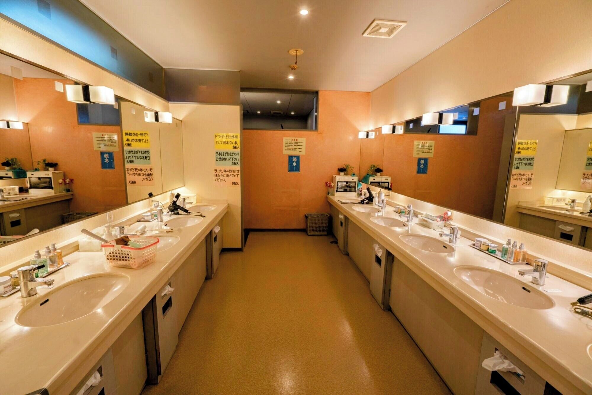 Une salle de bain d’hôtel avec deux lavabos, des miroirs et divers produits de toilette.