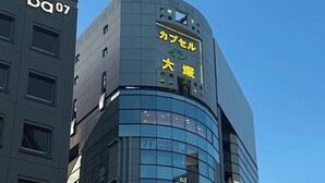 Edifici modern amb façana de vidre corbat i un rètol en japonès.