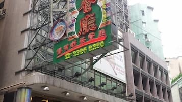 A multi-story building with a prominent green and red sign advertising a restaurant.