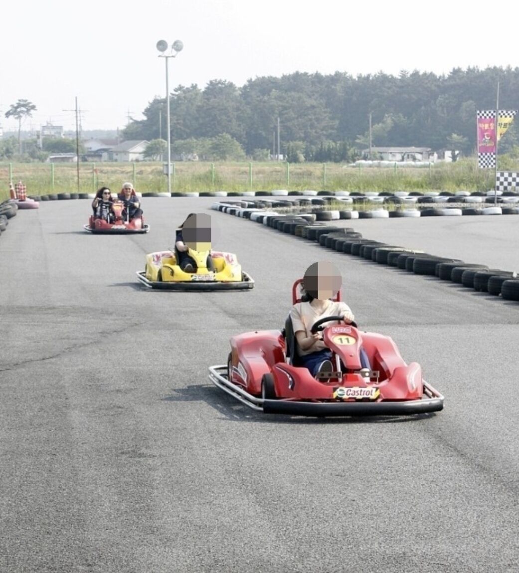 A go-kart track with multiple go-karts and drivers.