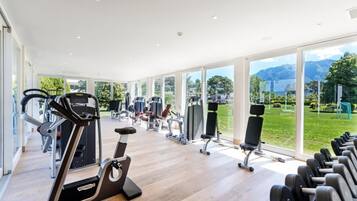 Un'ampia palestra con attrezzature cardio, macchinari per pesi e manubri.