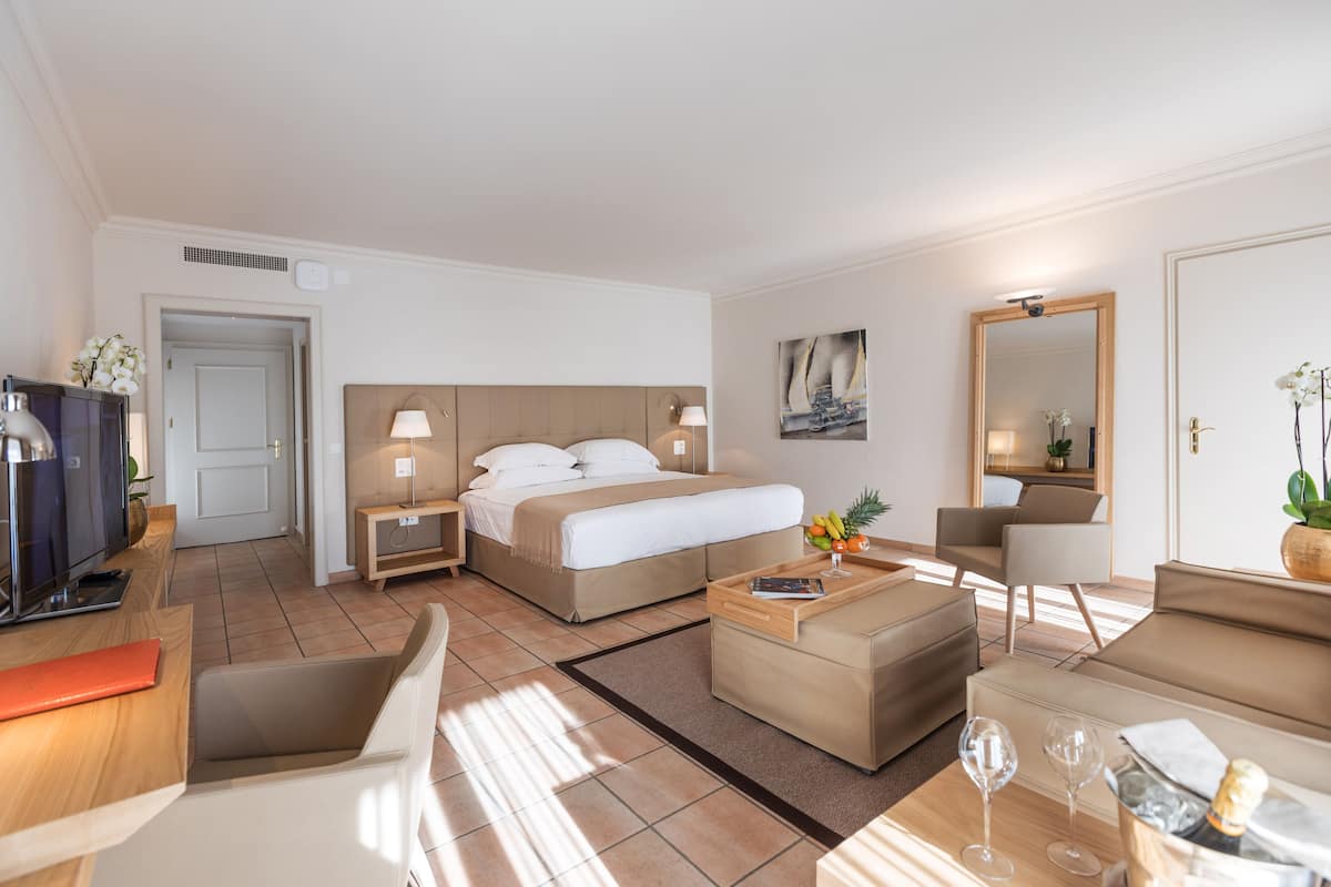 Una habitación de hotel moderna con cama, escritorio, silla, sofá y mesa de centro.