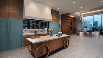 A modern kitchen with a central island, wooden cabinets, and a city view.