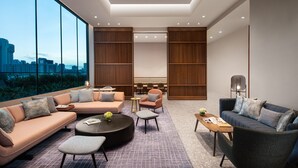 A modern interior with a large window, a sofa, a coffee table, and a chair. - Citadines Rochor Singapore (Singapore)