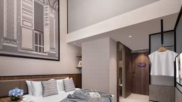 Una habitación de hotel moderna con una cama grande, un escritorio con una silla, un armario y una percha.