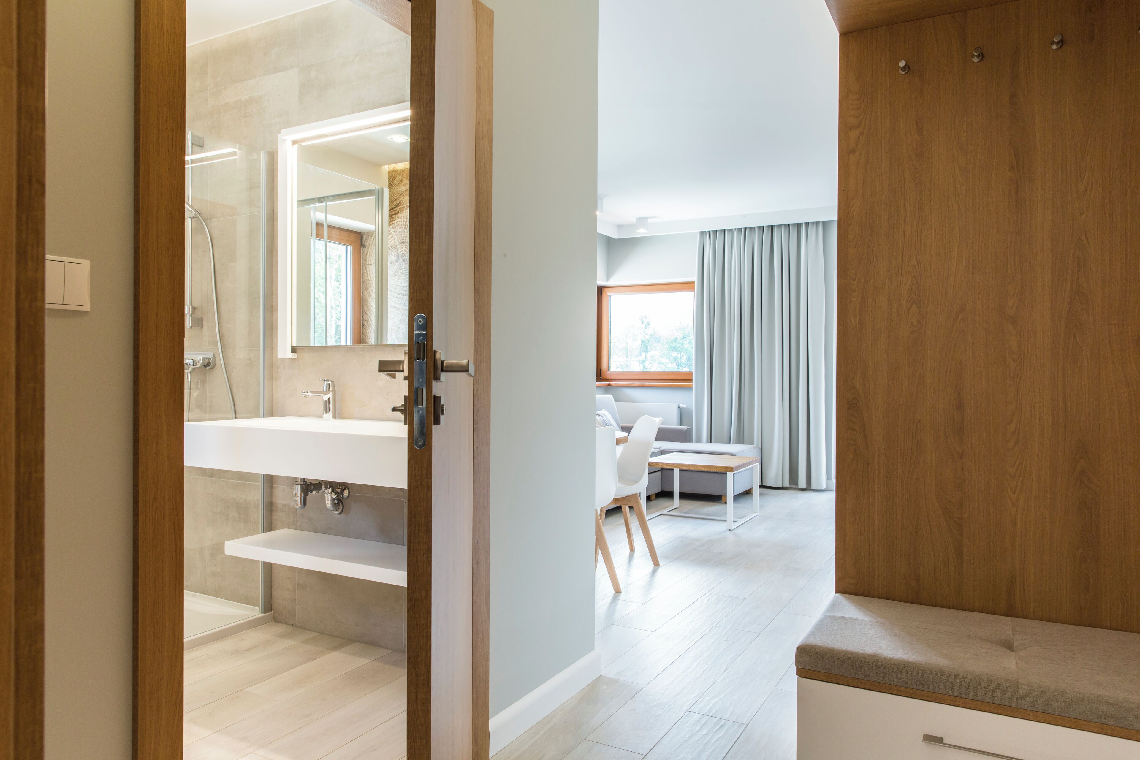 Un baño moderno con un espejo grande, un lavabo y una ducha.
