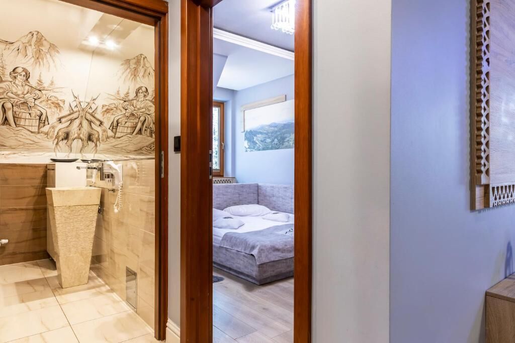 A bedroom with a bed, a bedside table, and a wall-mounted artwork.