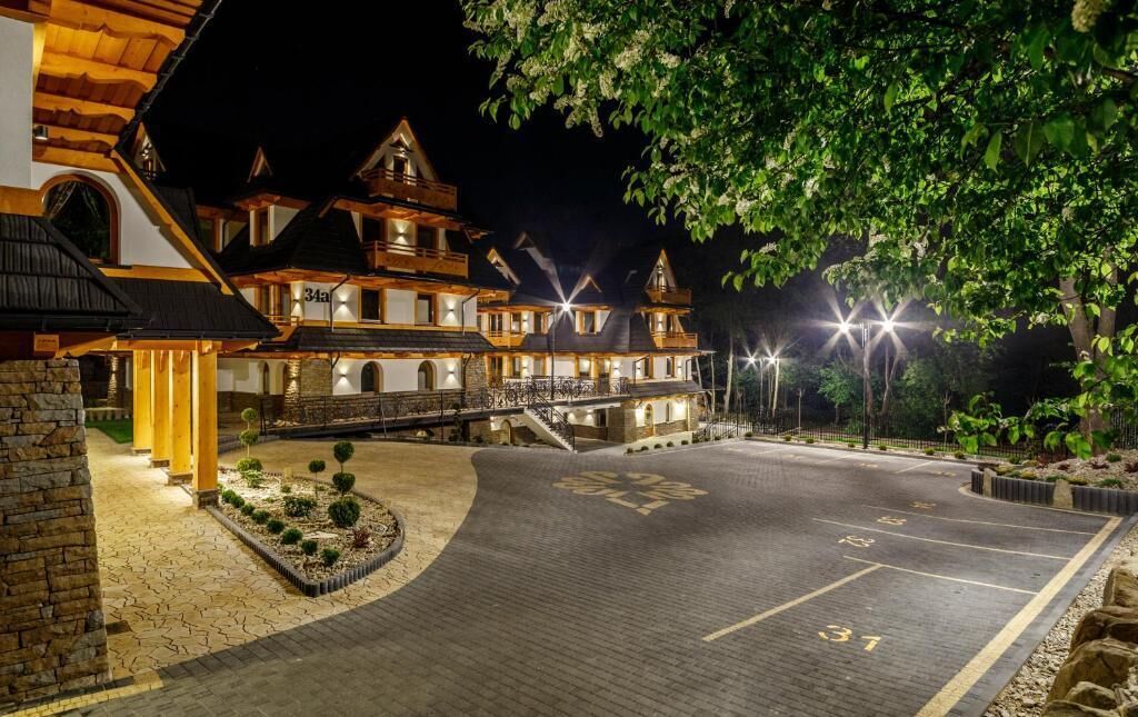 A multi-story hotel with a traditional architectural style, featuring a courtyard with a paved area and a small garden.
