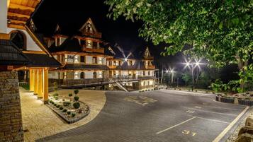 A multi-story hotel with a traditional architectural style, featuring a courtyard with a paved area and a small garden.