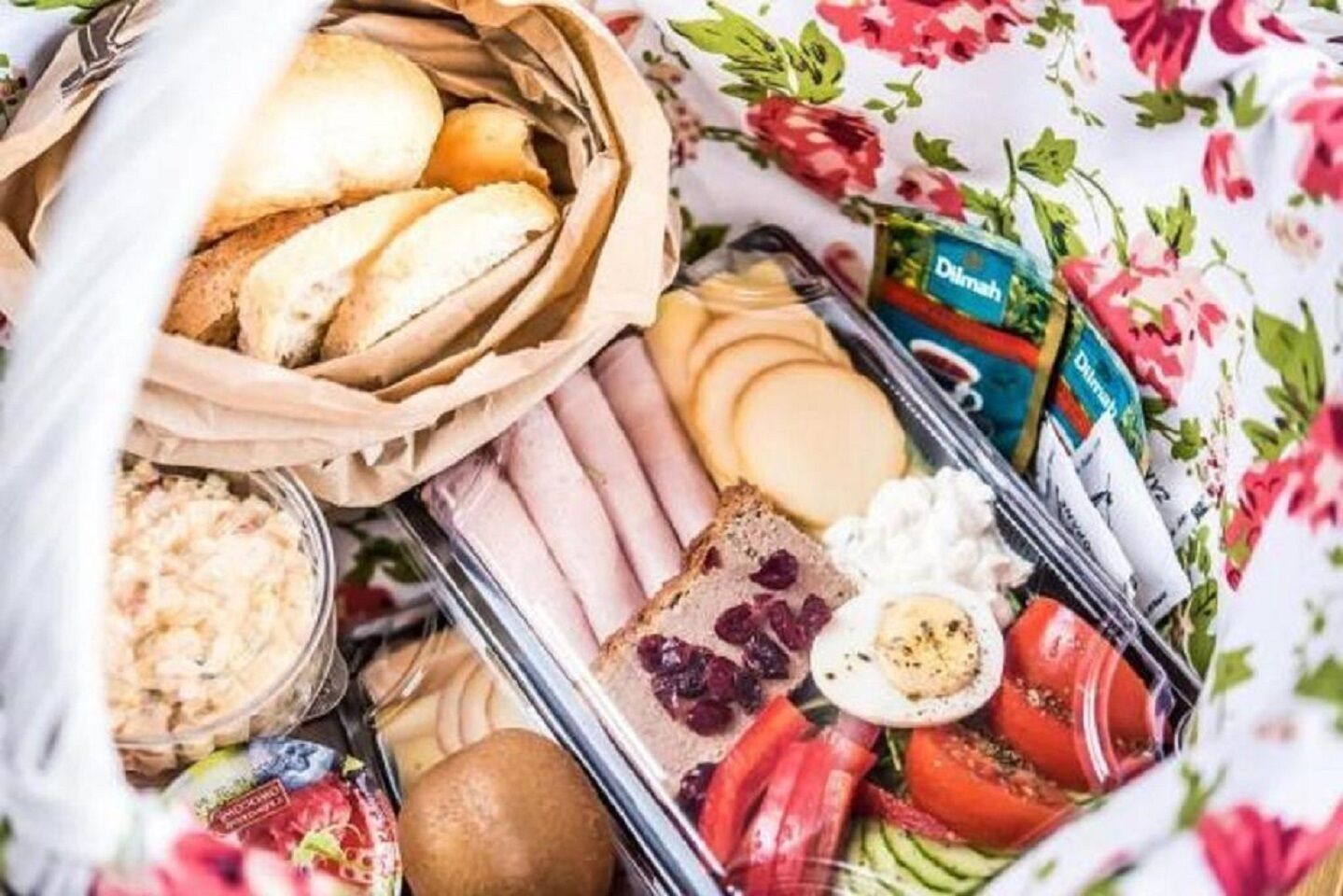 Eine Auswahl an Lebensmitteln, darunter Brot, Käse, Eier und Gemüse, auf einem Tisch drapiert.