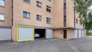 Un immeuble en briques à plusieurs étages, avec une entrée de garage.