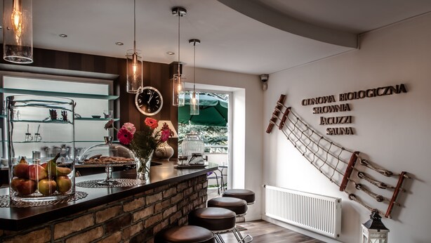 A modern bar area with a brick counter, stools, and a view of the outdoors. - Willa Bryza (Gdynia)