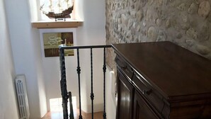 A staircase with a black balustrade leading to a landing. A wooden cabinet is on the landing. - Relais Sweet Days (Peschiera del Garda)
