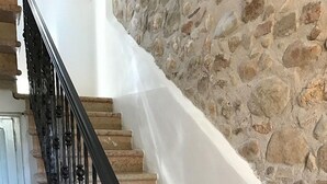 A staircase with a black metal railing, stone wall, and marble steps. - Relais Sweet Days (Peschiera del Garda)