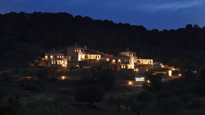 A large, multi-story stone building with multiple illuminated windows and a sign reading "Edav." - Edem Resort (Ermionida)