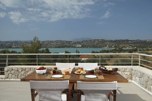 Mesa para dos con vista a un lago y colinas al fondo.