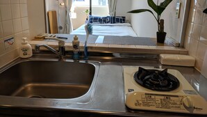 Une cuisine de taille réduite, équipée d’un évier, d’une cuisinière et d’un petit plan de travail.