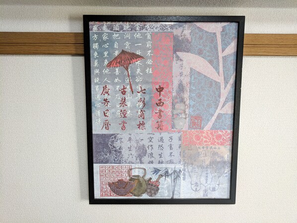 A framed artwork with Chinese calligraphy and traditional motifs.
