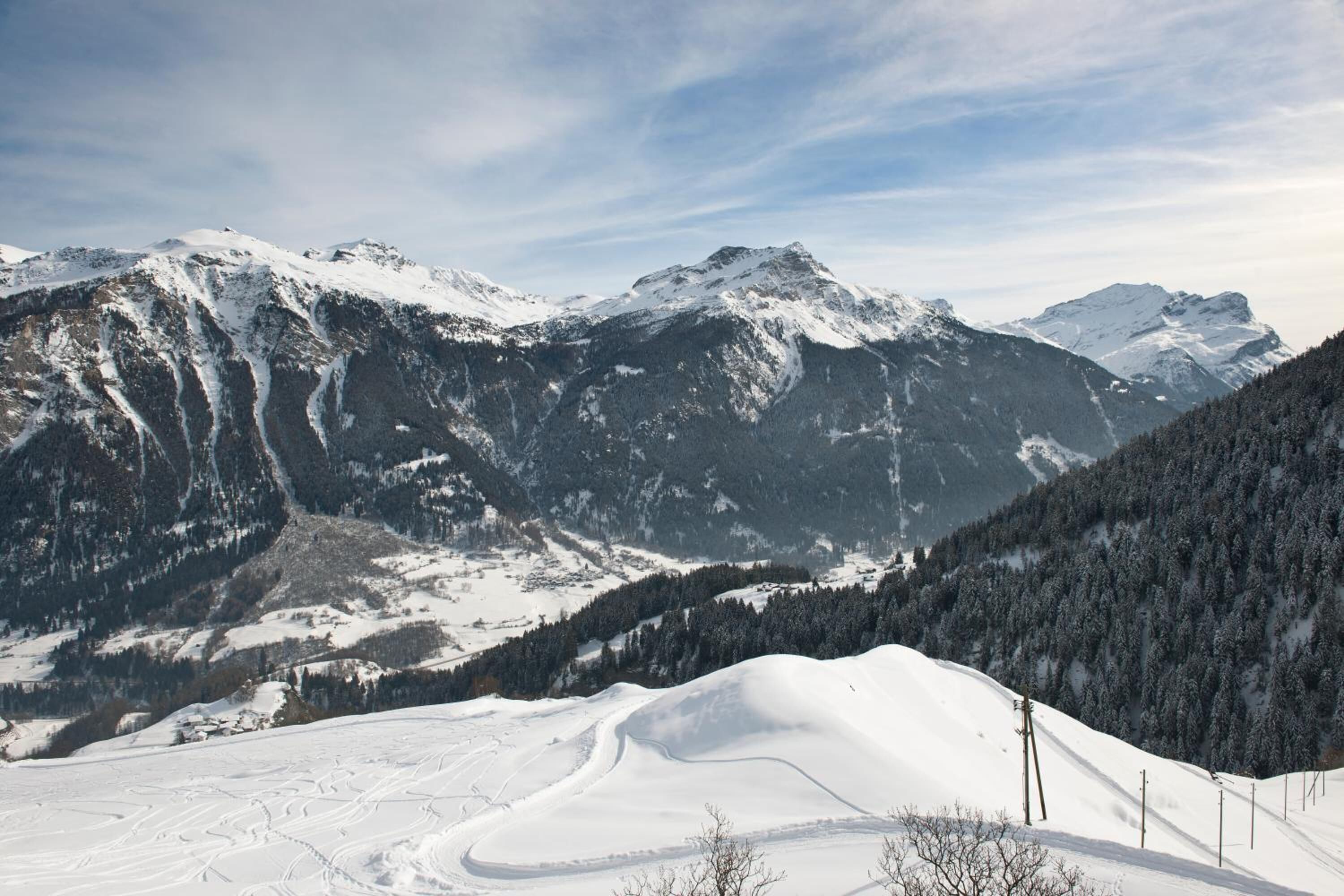 A snow-covered mountain landscape with a ski slope.