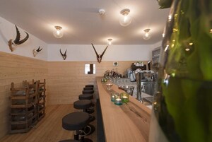 Zona de bar con paredes de madera, cráneos de animales montados y una barra con taburetes.