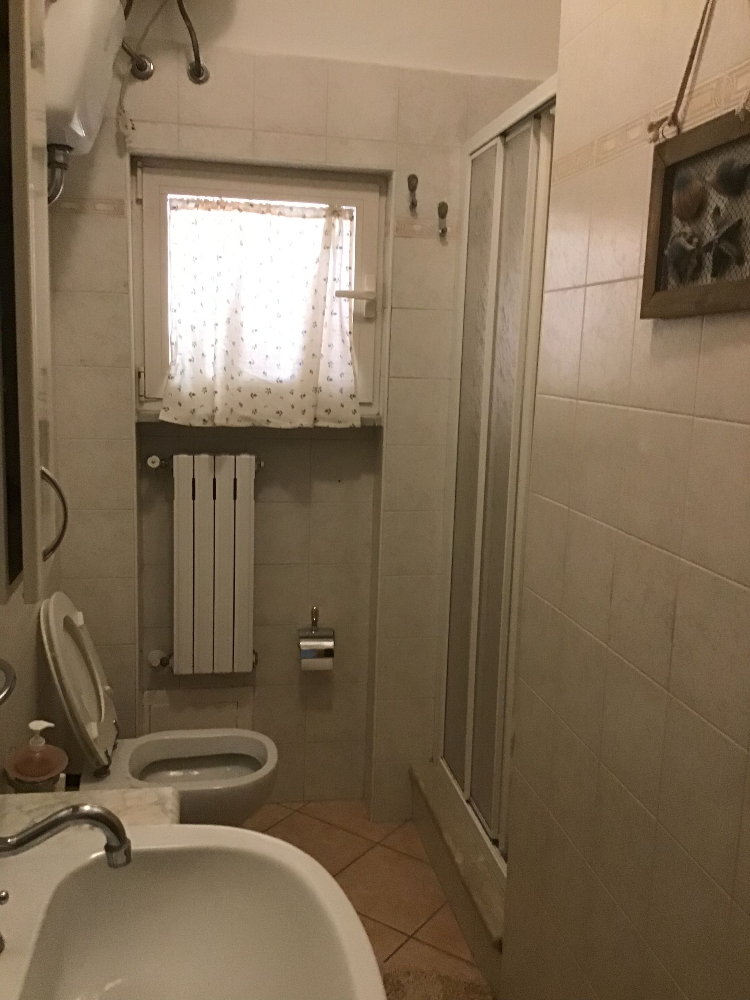 Ein kleines Badezimmer mit Toilette, Waschbecken und Dusche.