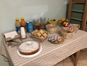 A table with food items, including bread, fruits, and beverages. - Achirina Bed and Breakfast (Cisterna di Latina)
