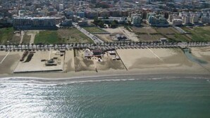 An aerial view of a coastal city with a beach, roads, and buildings. - B&B Charming House (Barletta)