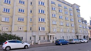 A multi-story hotel with a uniform facade, featuring a series of windows and balconies. - Stagedoor Apartment (Eastbourne)