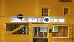 A building with a sign reading "NERJA BAHIA AT". - Nerja Bahía Apartamentos (Nerja)