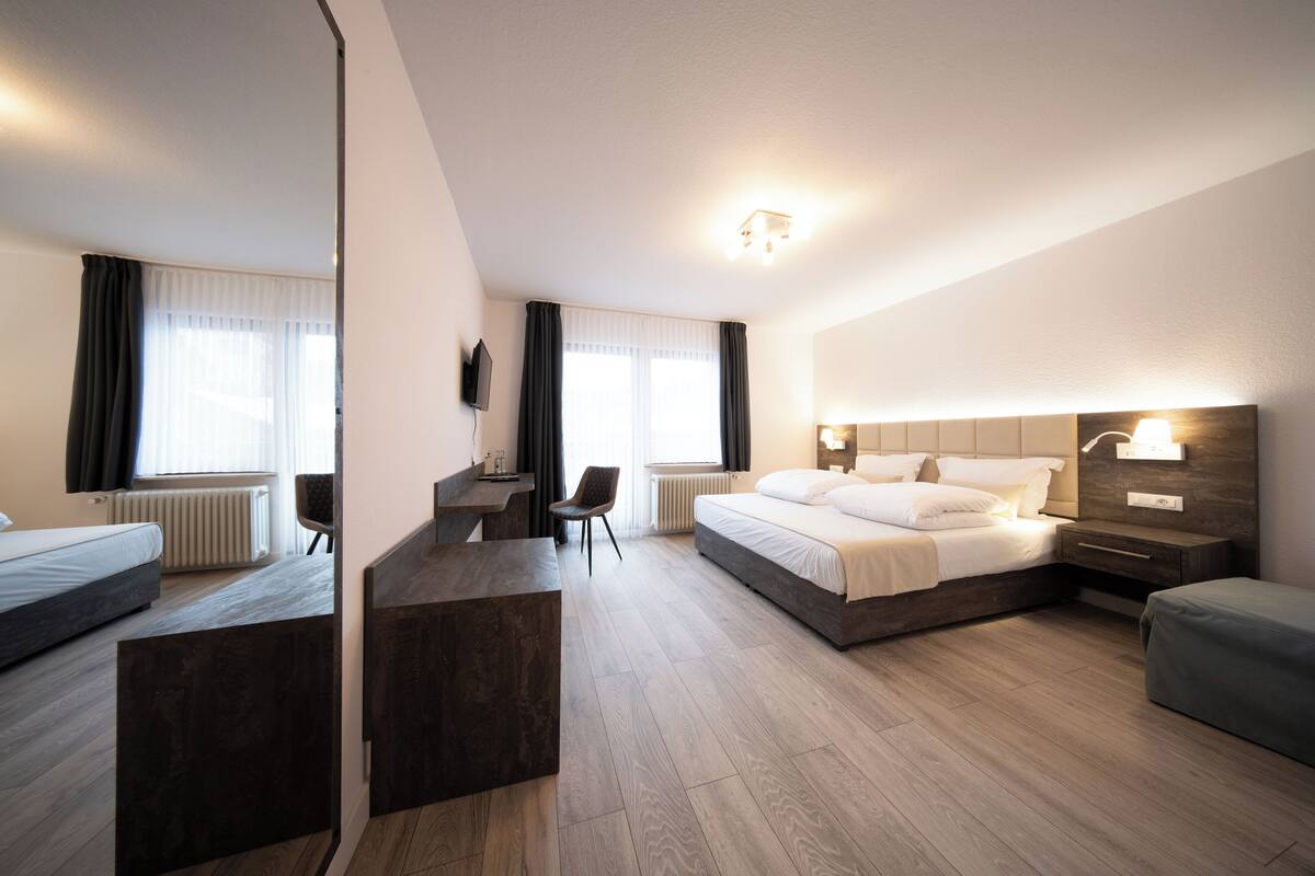 Une chambre d’hôtel moderne dotée d’un grand lit, d’un bureau et d’un coin salon.